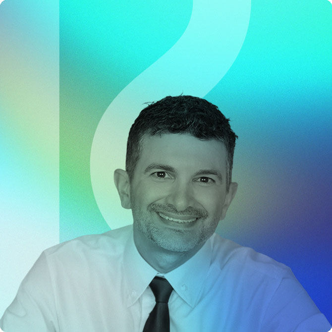 Smiling man in a white dress shirt and black tie, posing for a professional headshot against a teal-to-blue gradient background.
